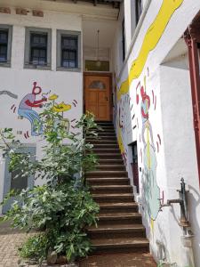 a stairway leading up to a building with a mural at the music hall in Schwanau