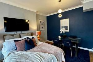 sypialnia z łóżkiem, biurkiem i telewizorem w obiekcie Stylish studio near Regent’s Park n7 w Londynie
