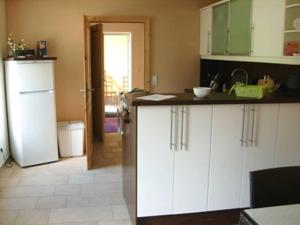 Una cocina con gabinetes blancos y un refrigerador. en Ferienhaus DH-38879, en Lubmin