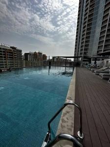 a large swimming pool on a balcony of a building at Cosy 1 bedroom Burj Khalifa view in Dubai