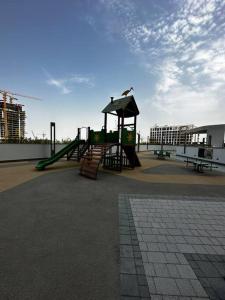 a playground with a slide and a play structure at Cosy 1 bedroom Burj Khalifa view in Dubai