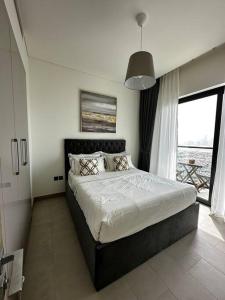 a bedroom with a large bed and a large window at Cosy 1 bedroom Burj Khalifa view in Dubai