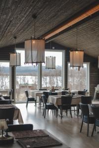 - une salle à manger avec des tables, des chaises et des fenêtres dans l'établissement Hotell Klimpfjäll, à Klimpfjäll