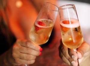 a person holding up two glasses of champagne at Casa Amor - Kinky Hotel UK in Southampton