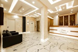 eine Lobby mit einem schwarzen Sofa und einem Marmorboden in der Unterkunft Perla Blanca Hotel in Trabzon