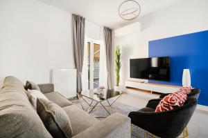 uma sala de estar com um sofá e uma televisão em GK Plato Academy em Atenas
