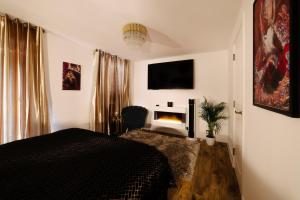 1 dormitorio con cama negra y chimenea en Casa Amor - Kinky Hotel UK, en Southampton