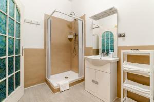 uma casa de banho com um chuveiro e um lavatório. em Inside Chiaia Rooms em Nápoles