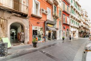 uma rua vazia com edifícios e pessoas andando na rua em Inside Chiaia Rooms em Nápoles