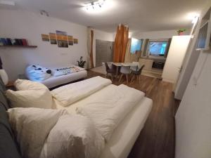 een woonkamer met 2 witte bedden en een eetkamer bij Apartment Riedhof in Fahrenbach