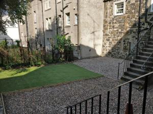 a small grass yard in front of a building at The Arches - The Big Yin in Stirling