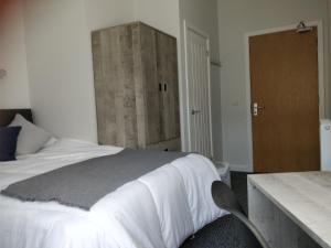 a bedroom with a large bed and a wooden cabinet at The Arches - The Big Yin in Stirling