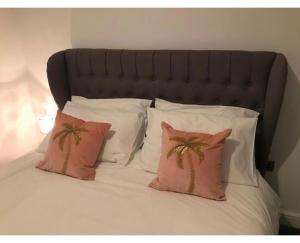 a bed with white pillows and palm trees on it at Apartments on Albert Road with free parking in Blackpool