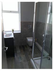 a bathroom with a shower and a toilet and a sink at Apartments on Albert Road with free parking in Blackpool
