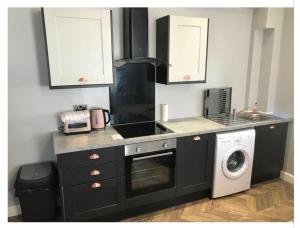 a kitchen with a sink and a washing machine at Apartments on Albert Road with free parking in Blackpool