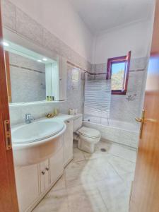 a bathroom with a sink and a toilet and a tub at Majestic View Resort in Nafpaktos