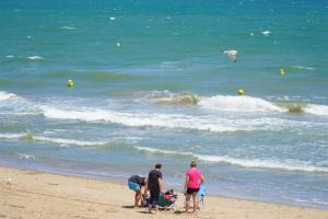 a group of people standing on the beach at Sea You Apartamentos Valencia Port Saplaya in Port Saplaya