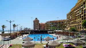 a large swimming pool with people in a resort at Sea You Apartamentos Valencia Port Saplaya in Port Saplaya