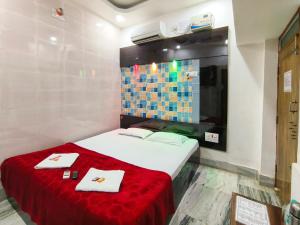 a bedroom with a bed with a red blanket and towels at Bobby Premium Residency in Puri