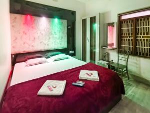 a bedroom with a bed with two towels on it at Bobby Premium Residency in Puri