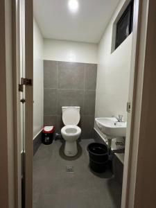 een badkamer met een toilet en een wastafel bij Maila's Lodging House in Casisang
