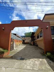 a red archway over a parking lot in a building at Maila's Lodging House in Casisang