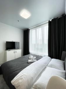 sypialnia z dużym łóżkiem i dużym oknem w obiekcie CUBE House w Kijowie