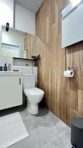 a bathroom with a white toilet and a wooden wall at CUBE House in Kyiv