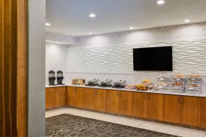 a food counter with a flat screen tv on a wall at SpringHill Suites Phoenix Downtown in Phoenix