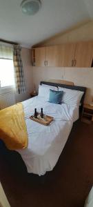a bedroom with a large white bed with a tray on it at Brilliant 6 Berth Caravan At Dovercourt Holiday Park Ref 44009a in Great Oakley