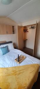 a bedroom with a bed with a tray on it at Brilliant 6 Berth Caravan At Dovercourt Holiday Park Ref 44009a in Great Oakley