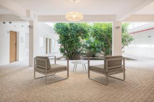 a room with two chairs and a table in a building at AlvorMar Apartamentos Turisticos in Alvor