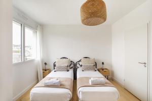 Ce lit se trouve dans un dortoir doté de murs blancs et d'une fenêtre. dans l'établissement L'Air - Elégant 2 chambres avec loggia dans résidence de haut standing, à Rennes