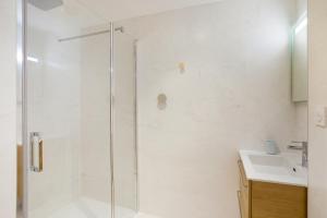 La salle de bains est pourvue d'une douche et d'un lavabo. dans l'établissement L'Air - Elégant 2 chambres avec loggia dans résidence de haut standing, à Rennes