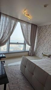 a bedroom with a bed and a large window at Reem Island 2BHK LUXURY APARTMENT! in Abu Dhabi