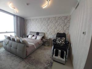 a bedroom with a bed and a couch and a chair at Reem Island 2BHK LUXURY APARTMENT! in Abu Dhabi