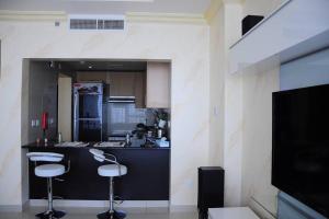 a kitchen with two bar stools and a counter top at Reem Island 2BHK LUXURY APARTMENT! in Abu Dhabi