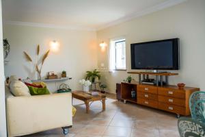 a living room with a tv and a couch at Apartamento Tocano Beach - By Dalma Portuguesa in Albufeira