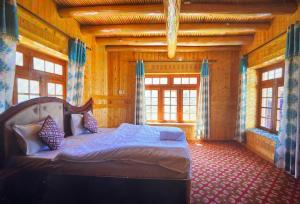 a bedroom with a bed in a room with windows at Guru view Home stay in Padam +5 photos