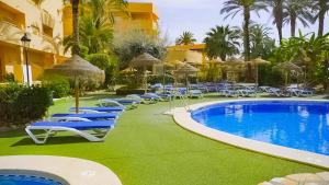 a pool with chairs and umbrellas next to a hotel at Hotel Mexico in Vera