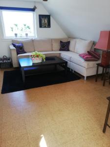 a living room with a couch and a table at Hunetorpvej Holiday Apartment in Blokhus