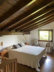 1 dormitorio con 1 cama grande y 2 sillas en Alberroakoborda, en Ituren