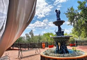 a statue of two people in a fountain next to benches at Agriturismo Kikajon in Linguaglossa