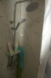 y baño con ducha y pared de piedra. en Life House en Bol'shevik