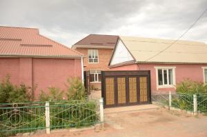 una casa con garaje y una casa rosa en Life House en Bol'shevik