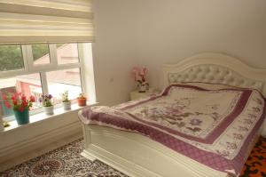 a bedroom with a bed and two windows at Life House in Bol'shevik