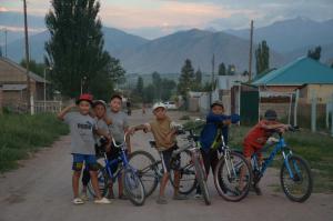 un grupo de niños parados con bicicletas en una carretera en Life House en Bol'shevik