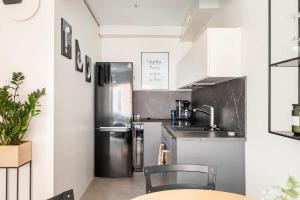 uma cozinha com um frigorífico de aço inoxidável e um lavatório em Modern 31sqm studio in Helsinki em Helsinque