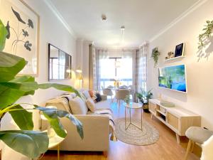 ein Wohnzimmer mit Sofa und Fernseher in der Unterkunft MAD SUITE Aeropuerto IFEMA in Madrid