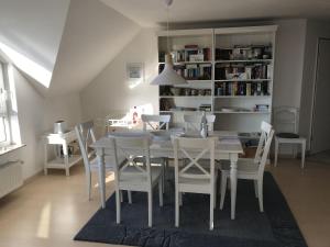 comedor con mesa blanca y sillas en Blaumuschel Haus C Wohnung 55 - DH, en Lubmin